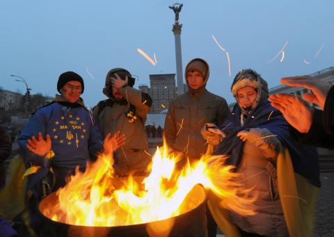 Участники Майдана в Киеве греются у бочек с огнем