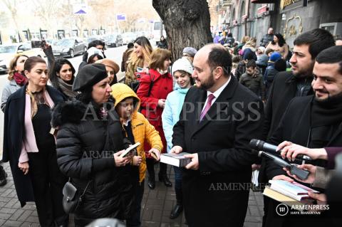 Education minister and staffers surprise passersby on Book 
Giving Day 