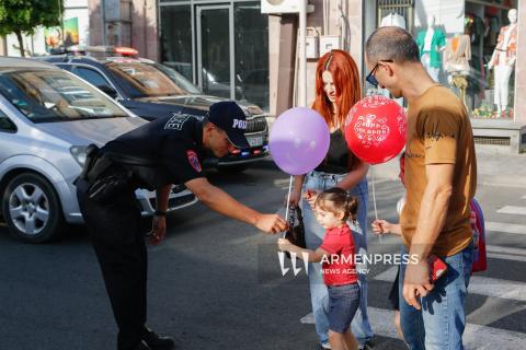 رجال دوريات الشرطة يقدمون بالونات للأطفال إيذاناً ببدء العام الدراسي