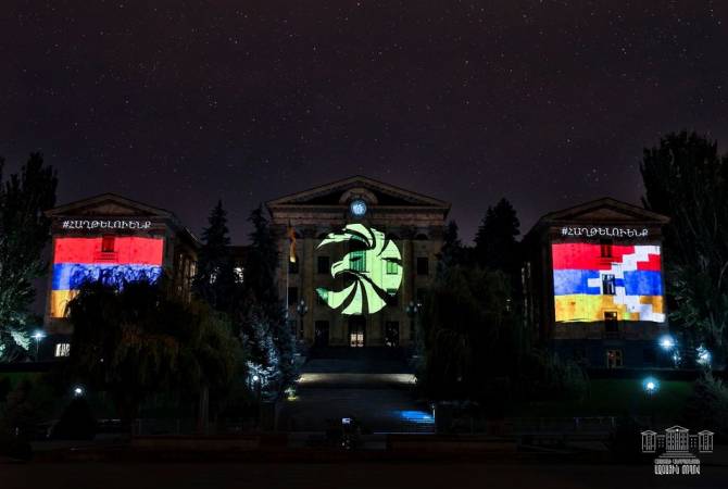 Armenian parliament building illuminated with flags of Armenia and Artsakh