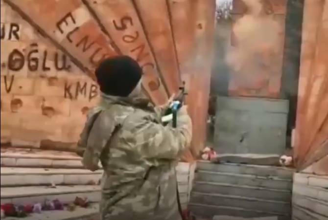 Un soldat azerbaïdjanais tire sur une pierre de croix arménienne à Hadrut