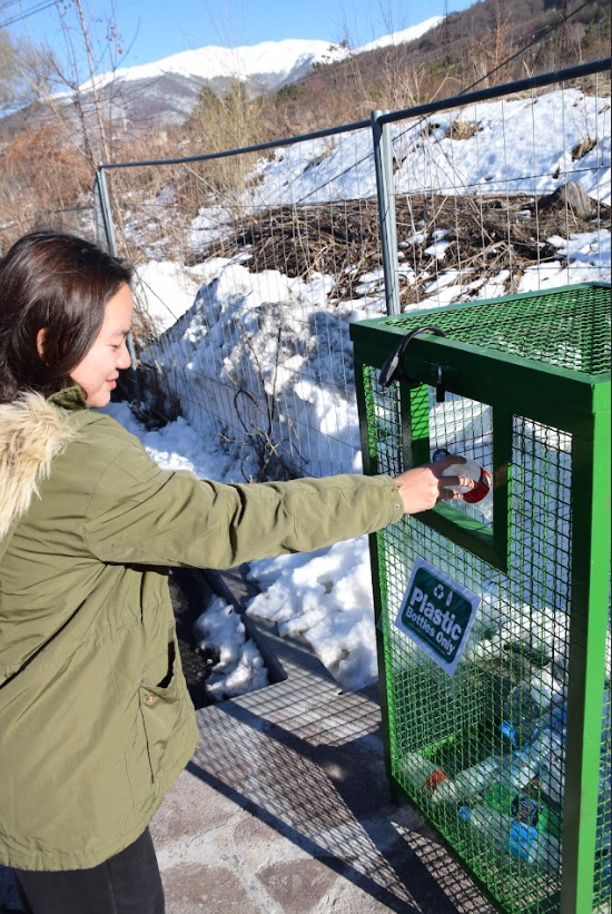 Picture of Chau disposing of a plastic bottle in the recycling bin 